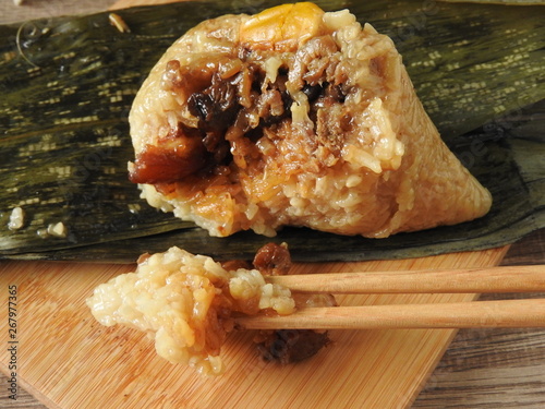 Close up of zongzi also called  rice dumplings or sticky rice dumplings. Eating with chopsticks  Dragon boat festival is a traditional festival of East Asian culture. Southern Taiwan taste.