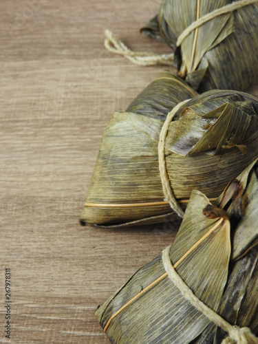 High angle view of zongzi also called rice dumplings or sticky rice dumplings on wooden background. Dragon boat festival is a traditional festival of East Asian culture. With copy space.