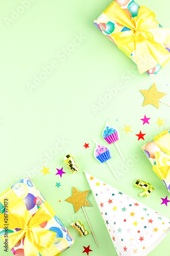 Birthday party background with wrapped gifts  confetti  party hats  decorations  top view
