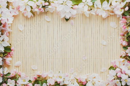 Frame of spring flowers of sakura on bamboo background. Beautiful cherry blossom sakura in springtime Low contrast