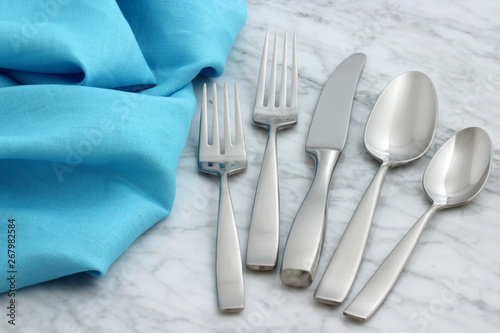 silverware and hemstitch napkin on antique carrara marble photo