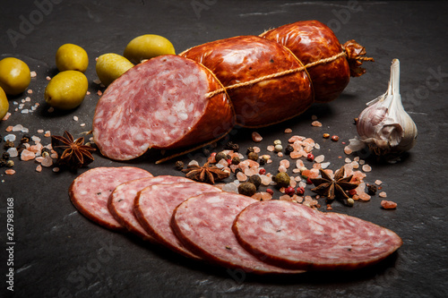 closeup salami smoked sausage with garlic and green olives