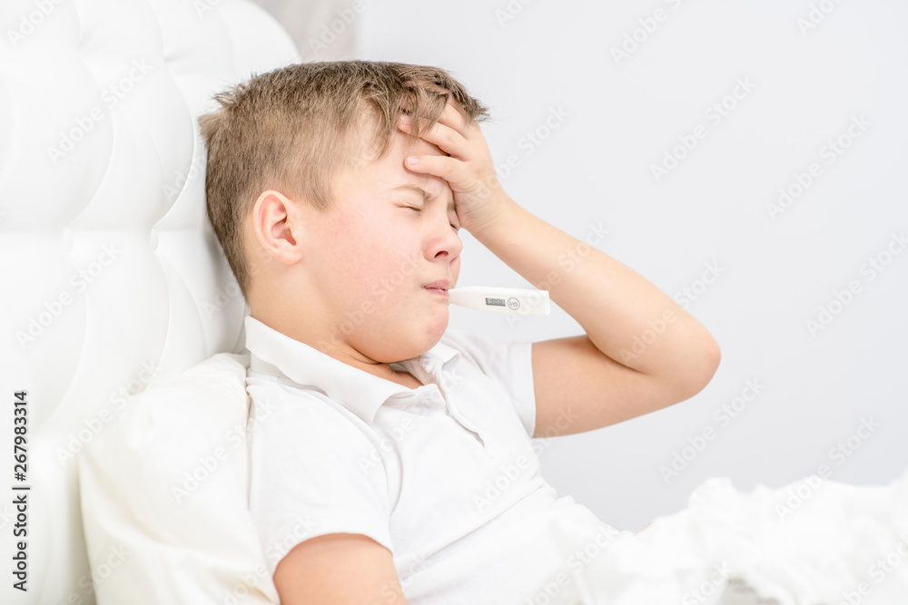 Sad sick young boy with thermometer in his mouth at home Sad sick young boy with thermometer in his mouth at home