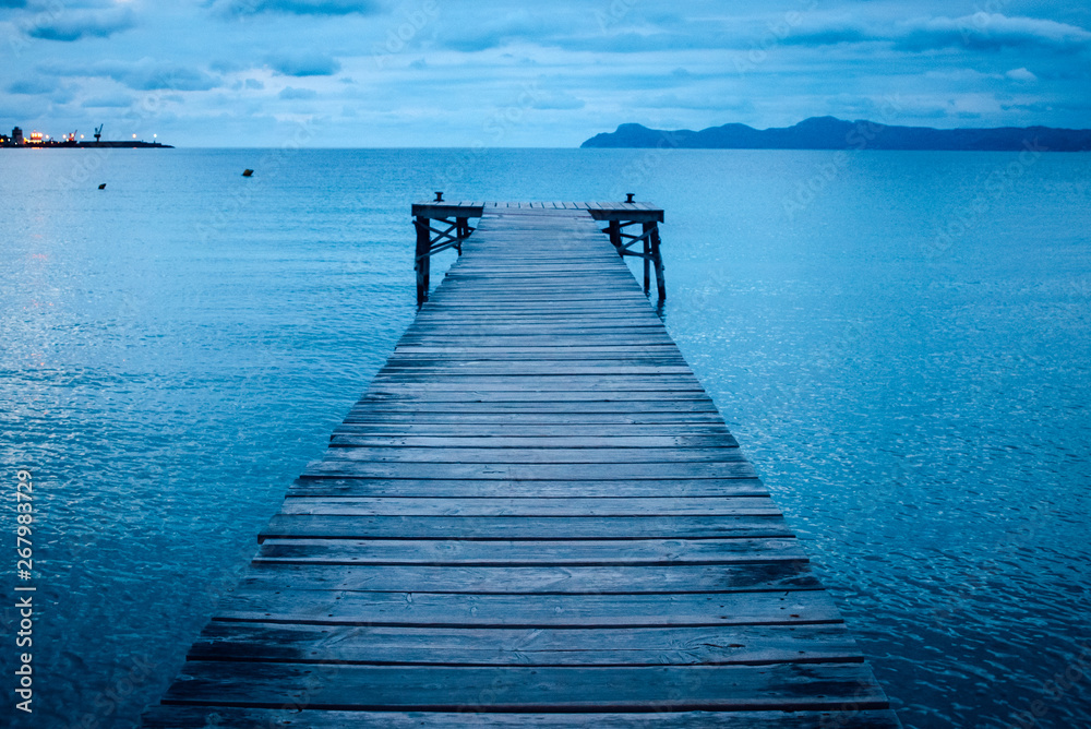 Dark morning by the sea. Pier in storm. Solitude, Loneliness concept photo