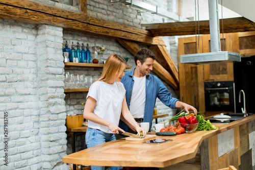 Lovely cheerful couple cook...