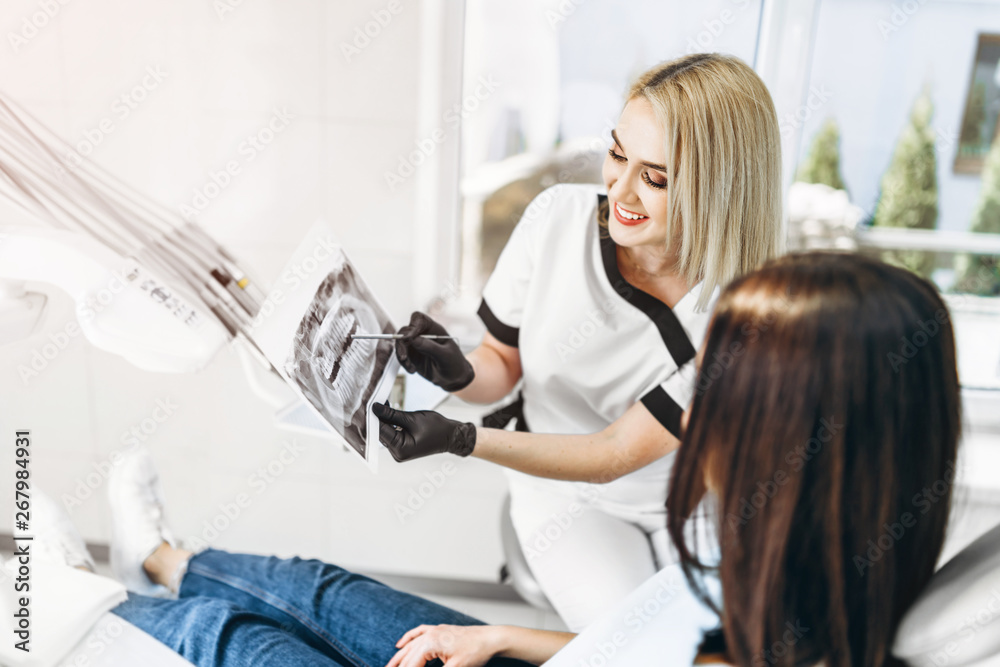 Dentist showing x-ray for the patient and explaining plan of treatment.