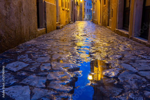 Streen after rain in Rovinj  with lamp reflection in a puddle photo