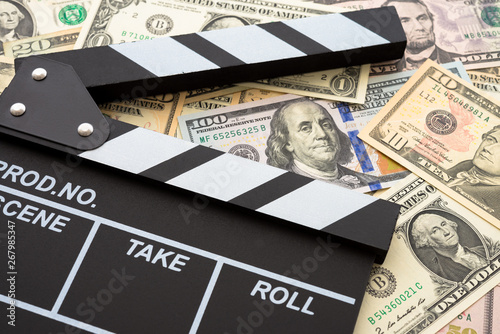 Fotografie Cinema clapperboard on US dollars banknote bill background - Movie entertainment