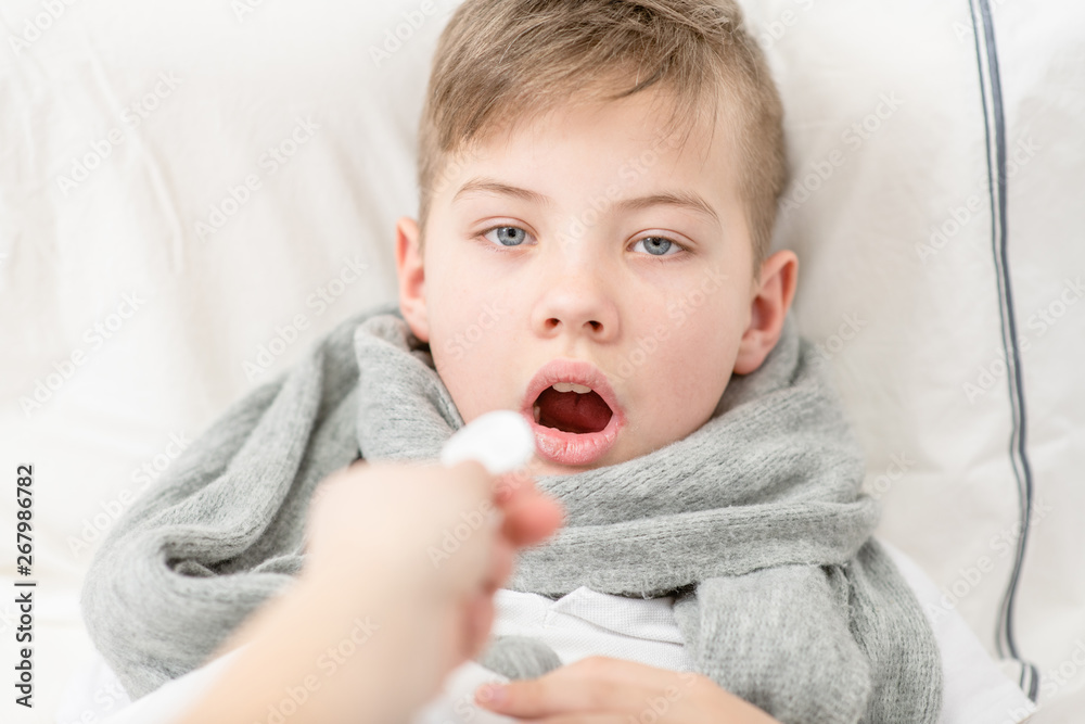 Sick little boy take medication pouring in a spoon Sick little boy take medication pouring in a spoon