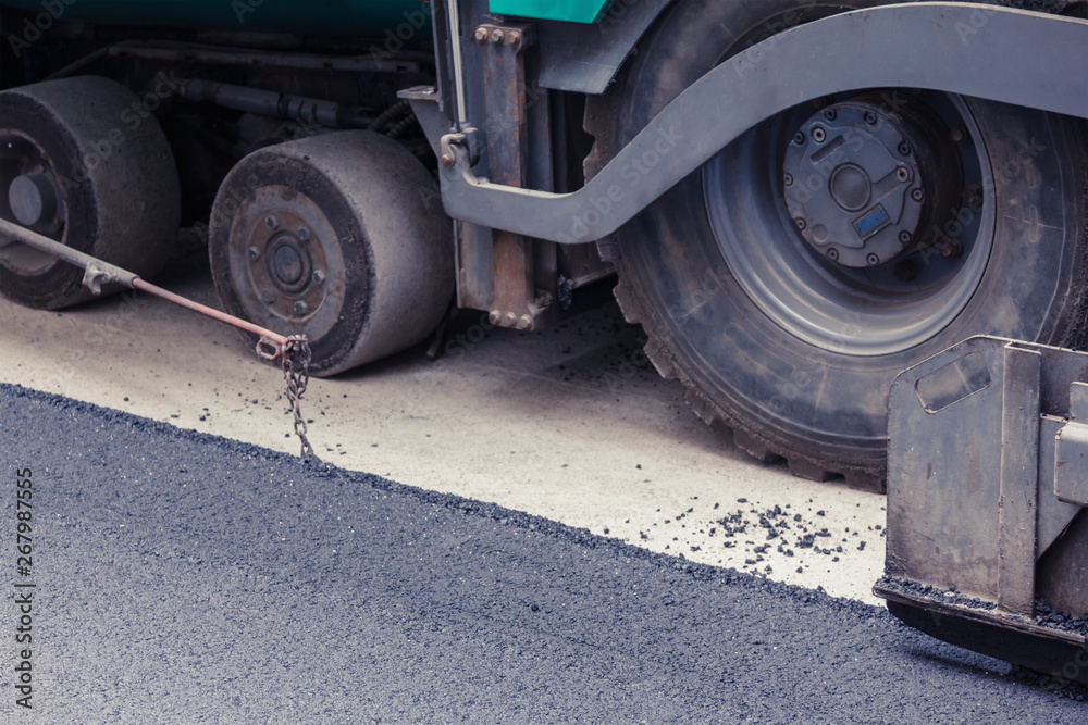 Fototapeta premium Paver makes the new asphalt on the road
