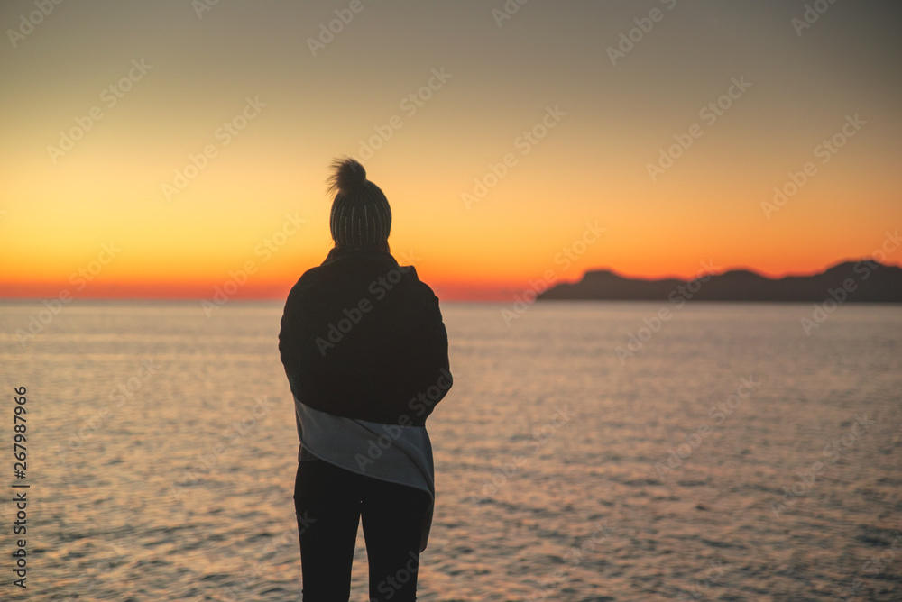Silhouette of woman, thinking and resting in the morning. Sunrise sky in background