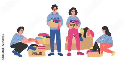 Group of volunteers sorts out clothes in cardboard boxes. 