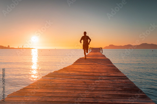 Morning Training. Runner train in beautiful sunrise light. Sport photo. Playa de Muro