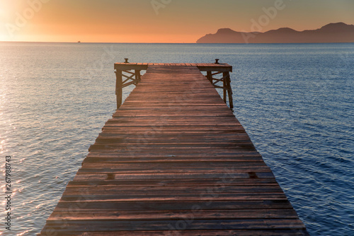 Pier in beautiful summer sunrise light. Warm orange colors  Mallorca  Spain
