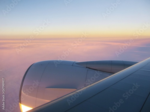 twilight sky with airplane wing and engine in foreground
