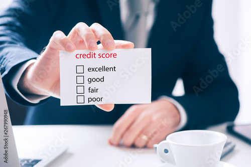 Foto Man in suit showing a signboard with the different ranges of the credit score