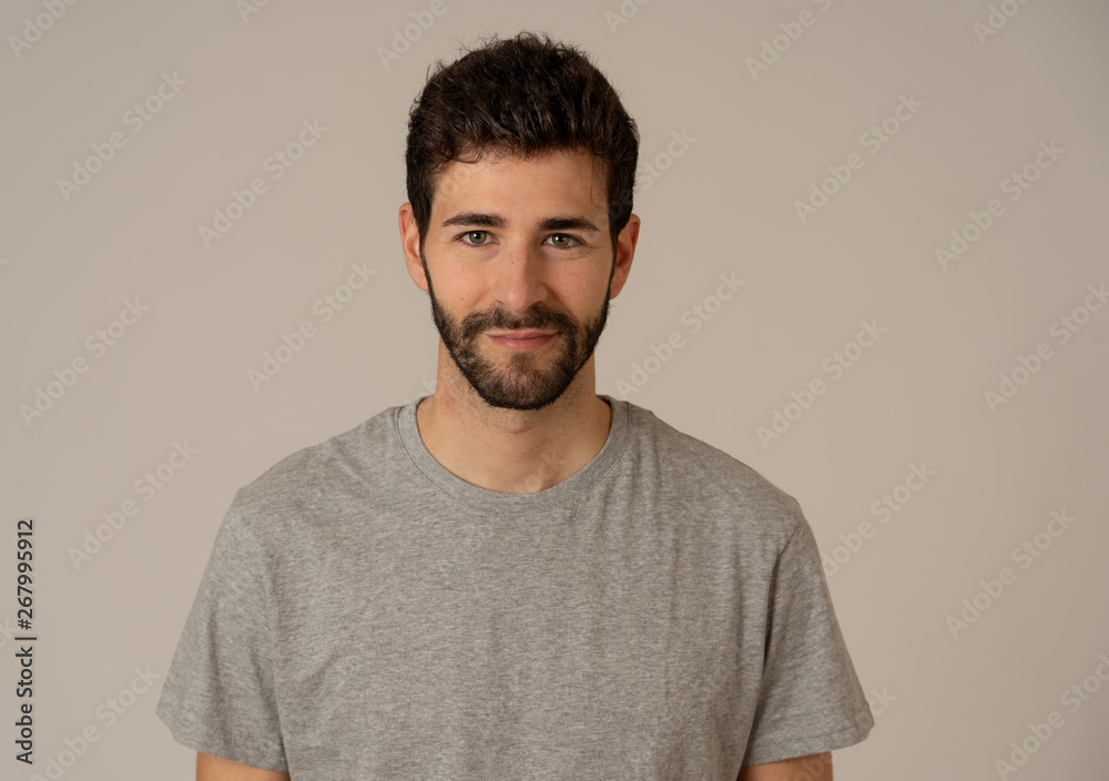 Fototapeta premium Natural portrait of young attractive man in his 20s looking and posing with neutral face expression