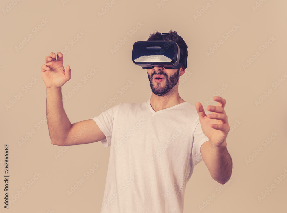 Fototapeta premium Portrait of excited and amazed young man wearing Virtual Reality headset exploring 3D world