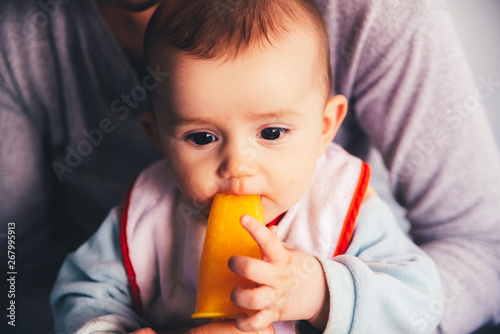 Baby savoring an orange ice cream.