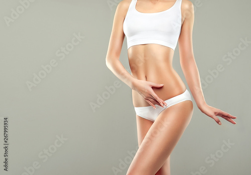  Perfect slim toned young body of the girl . An example of sports , fitness or plastic surgery and aesthetic cosmetology. photo