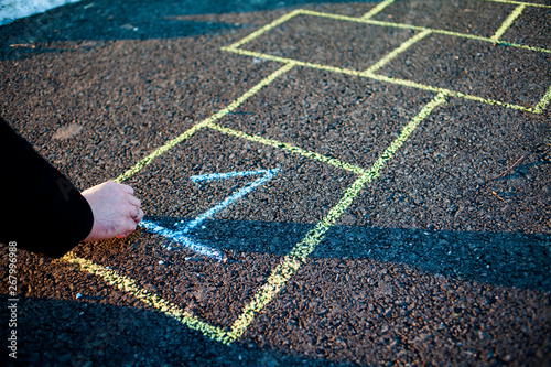 A young man draws hopscotch on asphalt. Good mood and spring in Russia. A bearded man recalls his childhood. photo