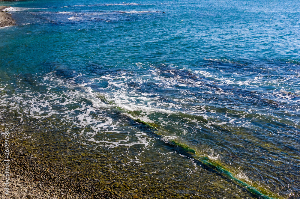 sea landscape is a pebbly beach with waves in white foam sea landscape is a pebbly beach with waves in white foam