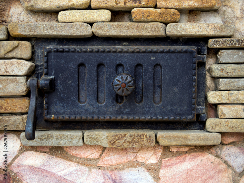 Blown stone stove with a decorative cast iron door