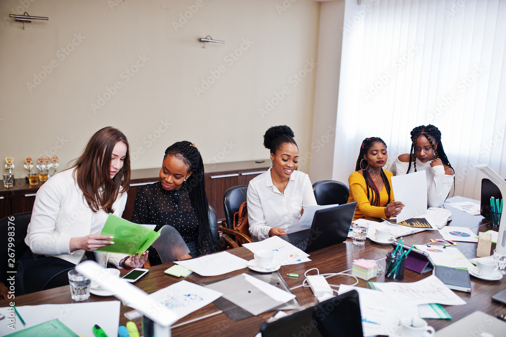 Fototapeta premium Multiracial women colleagues, crew of divercity female partners in office sit at the table.