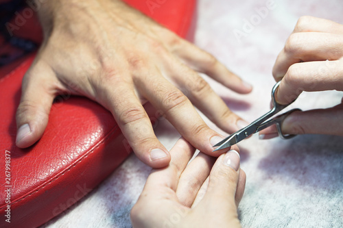Nail scissors in the hands of a professional. Salon Crassot. man hands in the process of work. Fashionable beauty theme. Stock photo