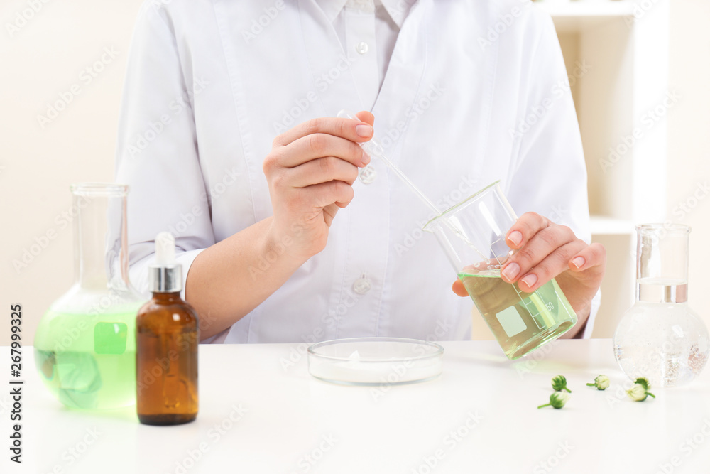 Female dermatologist creating skin care product at table, closeup Female dermatologist creating skin care product at table, closeup