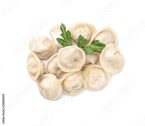 Pile of boiled dumplings with parsley leaves on white background, top view