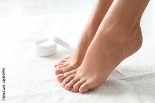 Woman with beautiful feet on white towel, closeup. Spa treatment