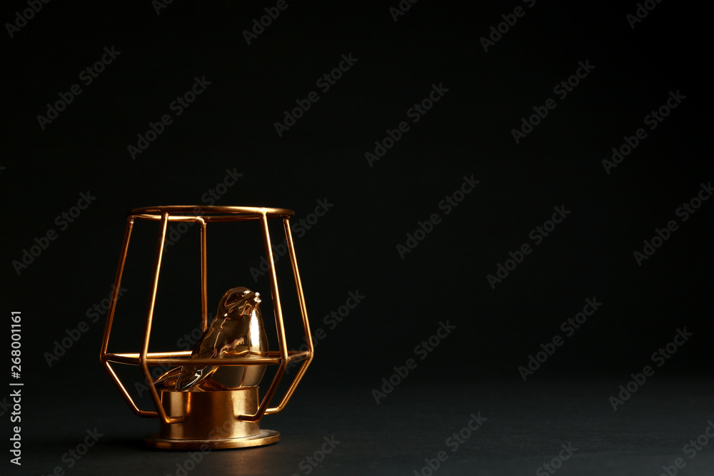Composition with decorative gold bird on black background. Space for text