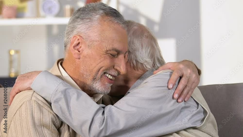 Elderly male friends talking and hugging, meeting brothers, holiday greeting Elderly male friends talking and hugging, meeting brothers, holiday greeting