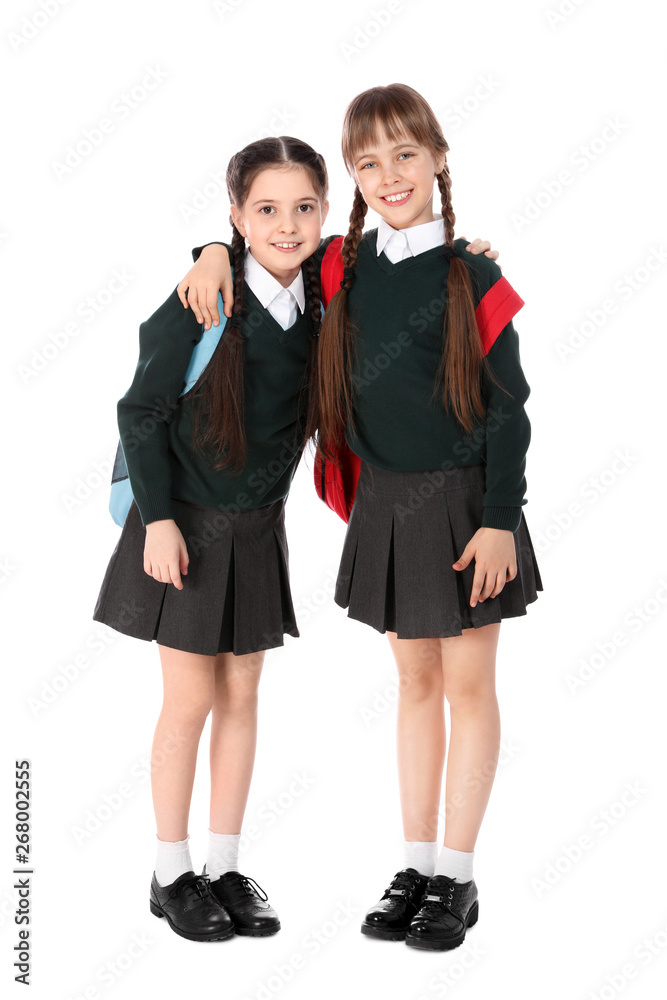 Full length portrait of cute girls in school uniform with backpacks on white background Full length portrait of cute girls in school uniform with backpacks on white background