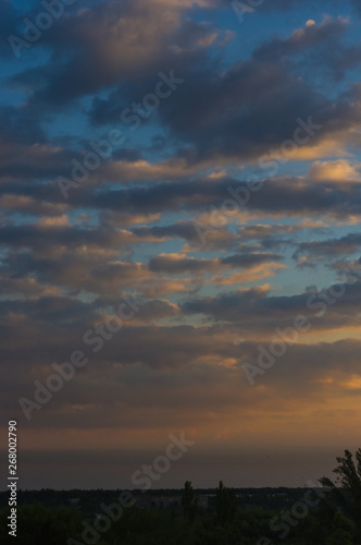 Landscape with dramatic light - beautiful golden sunset with saturated sky and clouds.