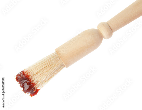 Basting brush with barbecue sauce on white background
