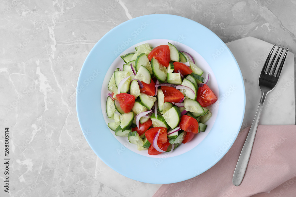 Plate of vegetarian salad with cucumber, tomato and onion served on table, flat lay Plate of vegetarian salad with cucumber, tomato and onion served on table, flat lay