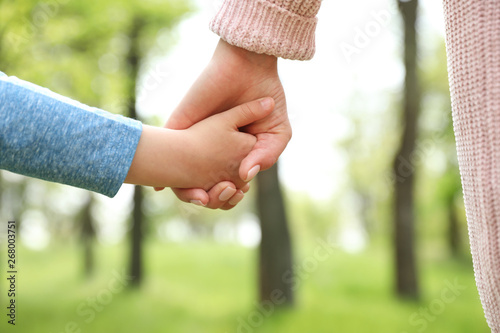Bild auf Leinwand Little child holding hands with his mother outdoors, closeup