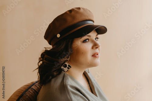 Indoor fashion portrait of plus size woman wearing trendy animal, leopard print. Concept of autumn and winter clothes, outfit for glamour woman in city. Copy space.