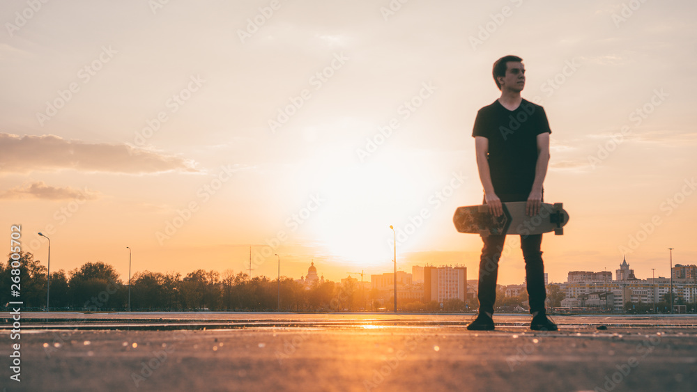 The guy with the longboard at sunset.