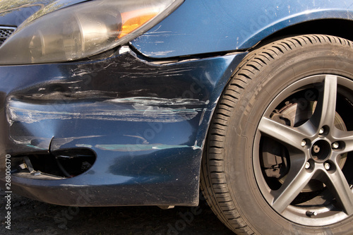 Damaged car. Broken front bumper. The concept of road safety. Close up.