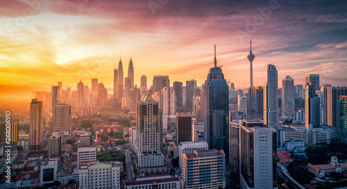 Cityscape of Kuala lumpur city skyline with swimming pool on the roof top of hotel at sunrise in Malaysia.