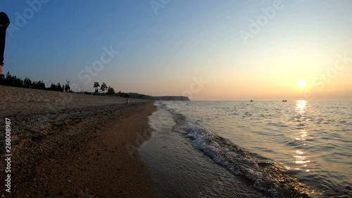 Wallpaper Mural Man walks along the shore of lake Baikal at sunset. Slow motion Torontodigital.ca