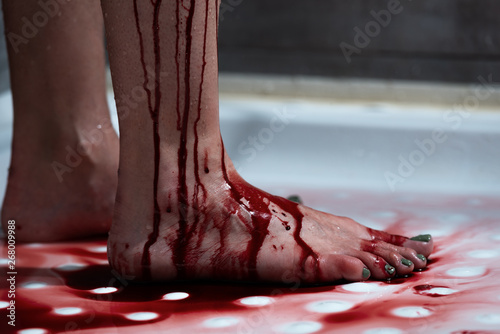 cropped view of barefoot bleeding woman in bathroom