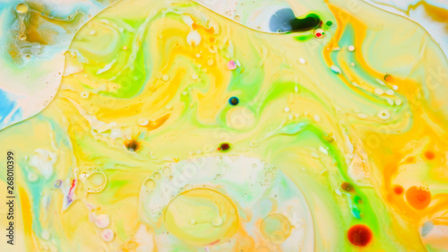 Multicolored background with oil on liquid. Abstract golden green background on liquid. Pattern with multicolored spots. Fluid art