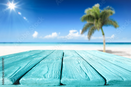 Wooden desk of free space and summer beach with palms 