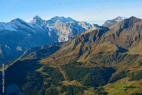 Aerial view of the mountainsides and high snowy mountains peaks at the morning in Lauterbrunnen valley in Switzerland.