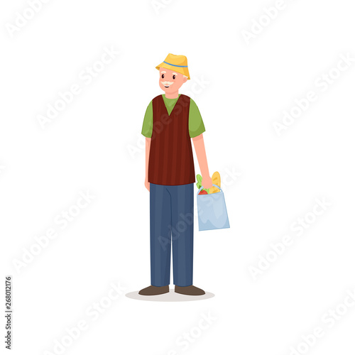 Cute smiling pensioner man with yellow hat and products bag