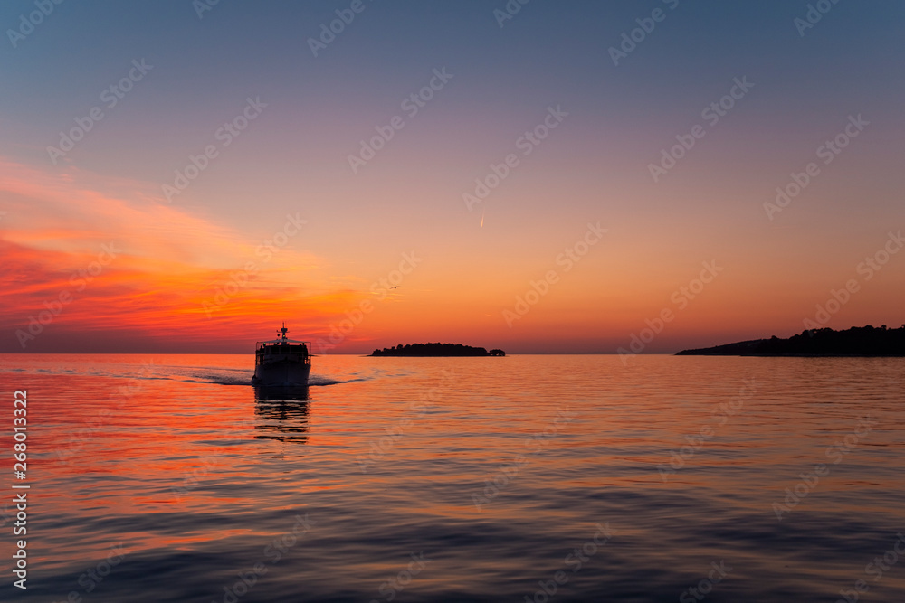 Sunset over the sea with a ship at Rovinj, Croatia